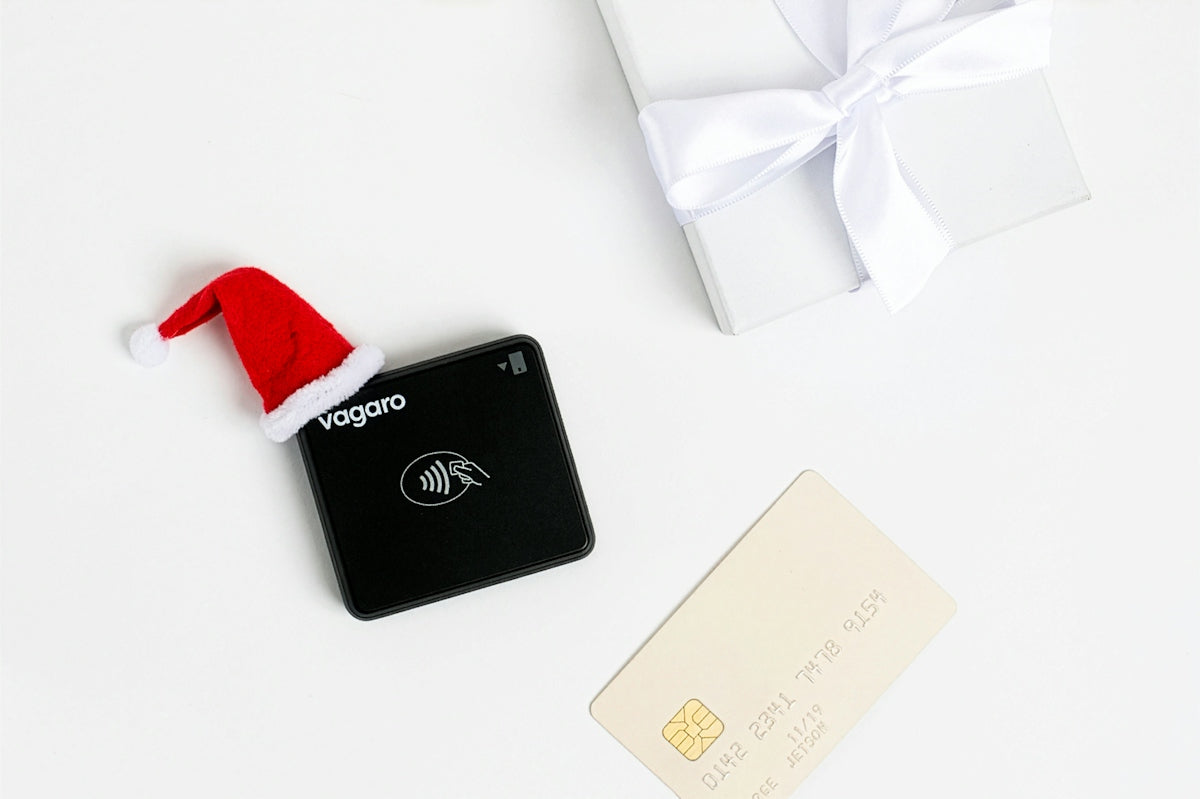 Black payment terminal with santa hat and gift