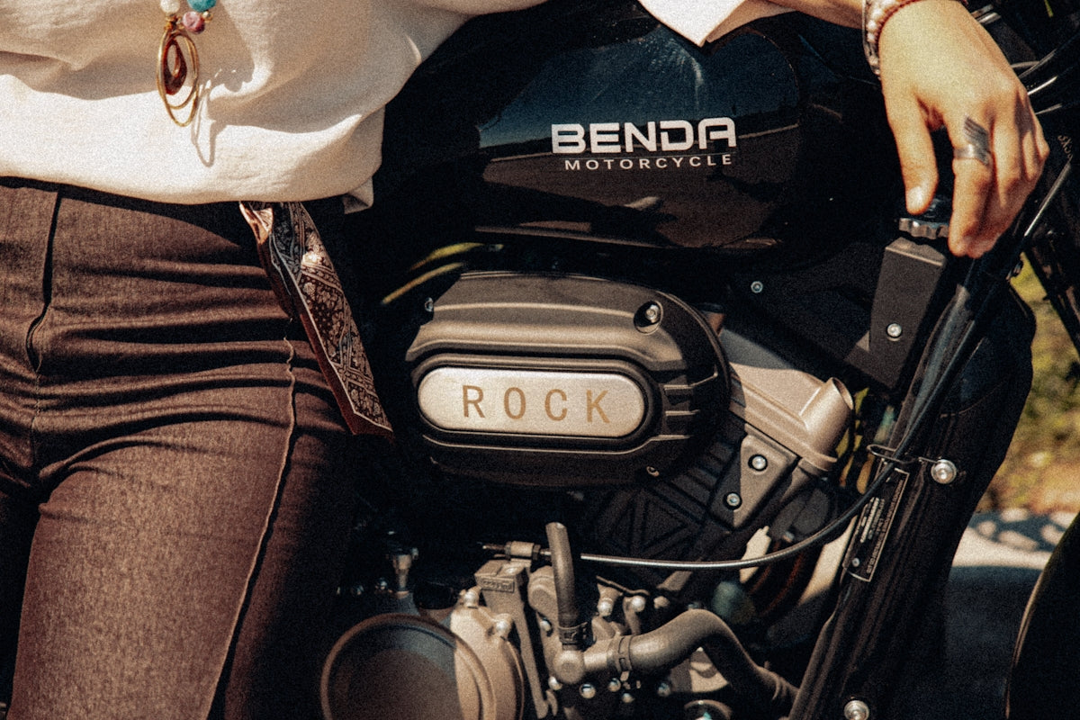 Person sitting on a motorcycle with rock emblem