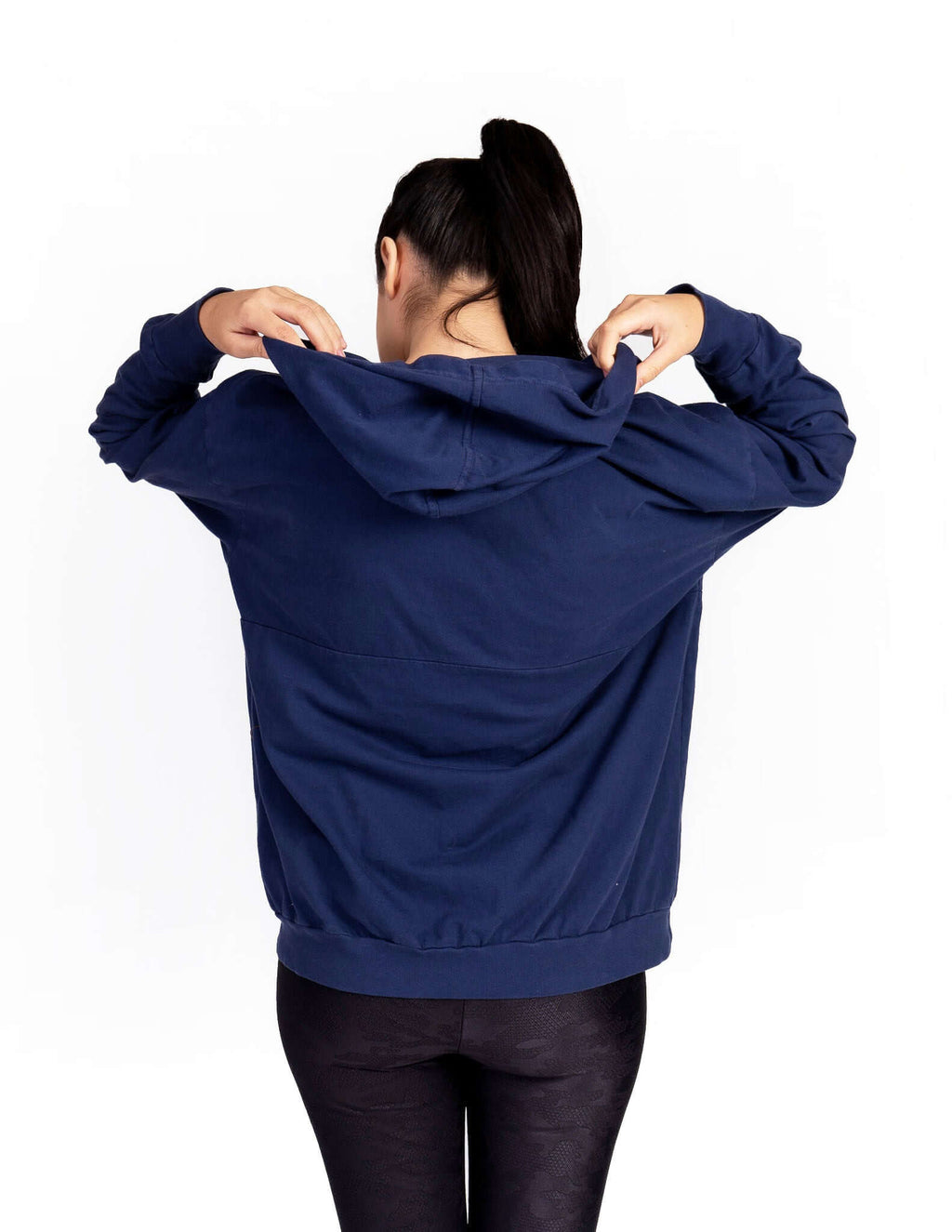 Woman wearing a navy Relax Hoodie with oversized fit, showcasing the generous hood and back design.
