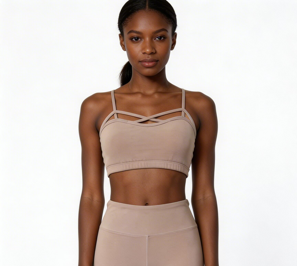 Woman wearing a beige sports bra and leggings on a white background